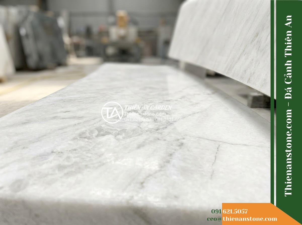 Ghế Đá Sân Trường Tri Thức – Kích thước 170 x 48 x 80 cm – Kiểu dáng tựa nan dọc, mặt ngồi rộng. Chất liệu đá hoa cương - Hình 5 Ghế Đá Sân Trường Tri Thức – Kích thước 170 x 48 x 80 cm – Kiểu dáng tựa nan dọc, mặt ngồi rộng. Chất liệu đá hoa cương - Professional installation of a granite stone bench in a landscaped garden, worke