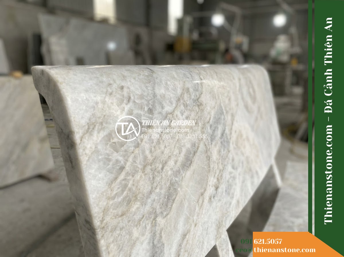 Ghế Đá Sân Trường Tri Thức – Kích thước 170 x 48 x 80 cm – Kiểu dáng tựa nan dọc, mặt ngồi rộng. Chất liệu đá vàng cẩm thạch - Hình 3 Ghế Đá Sân Trường Tri Thức – Kích thước 170 x 48 x 80 cm – Kiểu dáng tựa nan dọc, mặt ngồi rộng. Chất liệu đá vàng cẩm thạch - Autumn scene with fallen leaves scattered on a golden marble stone bench in a pe