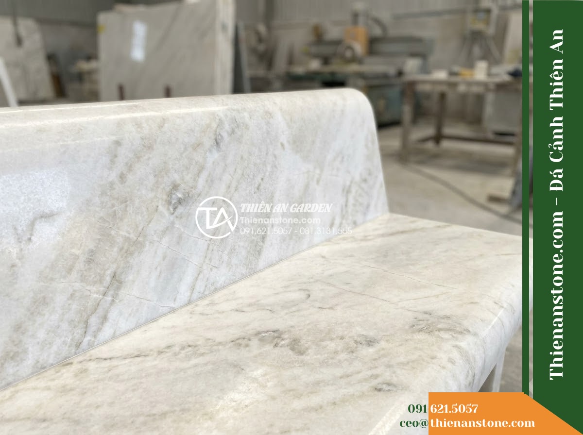 Ghế Đá Sân Trường Tuổi Thơ – Kích thước 145 x 44 x 45 cm – Kiểu dáng băng thấp, hai đầu bo tròn. Chất liệu đá vàng cẩm thạch - Hình 3 Ghế Đá Sân Trường Tuổi Thơ – Kích thước 145 x 44 x 45 cm – Kiểu dáng băng thấp, hai đầu bo tròn. Chất liệu đá vàng cẩm thạch - golden marble stone bench flanked by potted bonsai trees on a resort terrace ove