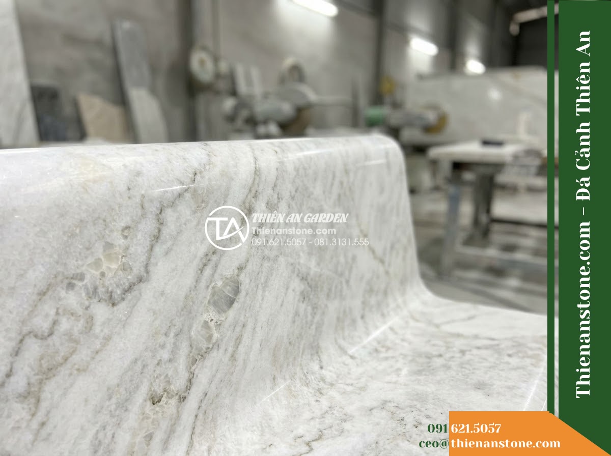 Ghế Đá Sân Trường Tuổi Thơ – Kích thước 145 x 44 x 45 cm – Kiểu dáng băng thấp, hai đầu bo tròn. Chất liệu đá vàng cẩm thạch - Hình 5 Ghế Đá Sân Trường Tuổi Thơ – Kích thước 145 x 44 x 45 cm – Kiểu dáng băng thấp, hai đầu bo tròn. Chất liệu đá vàng cẩm thạch - Professional installation of a golden marble stone bench in a landscaped garden,