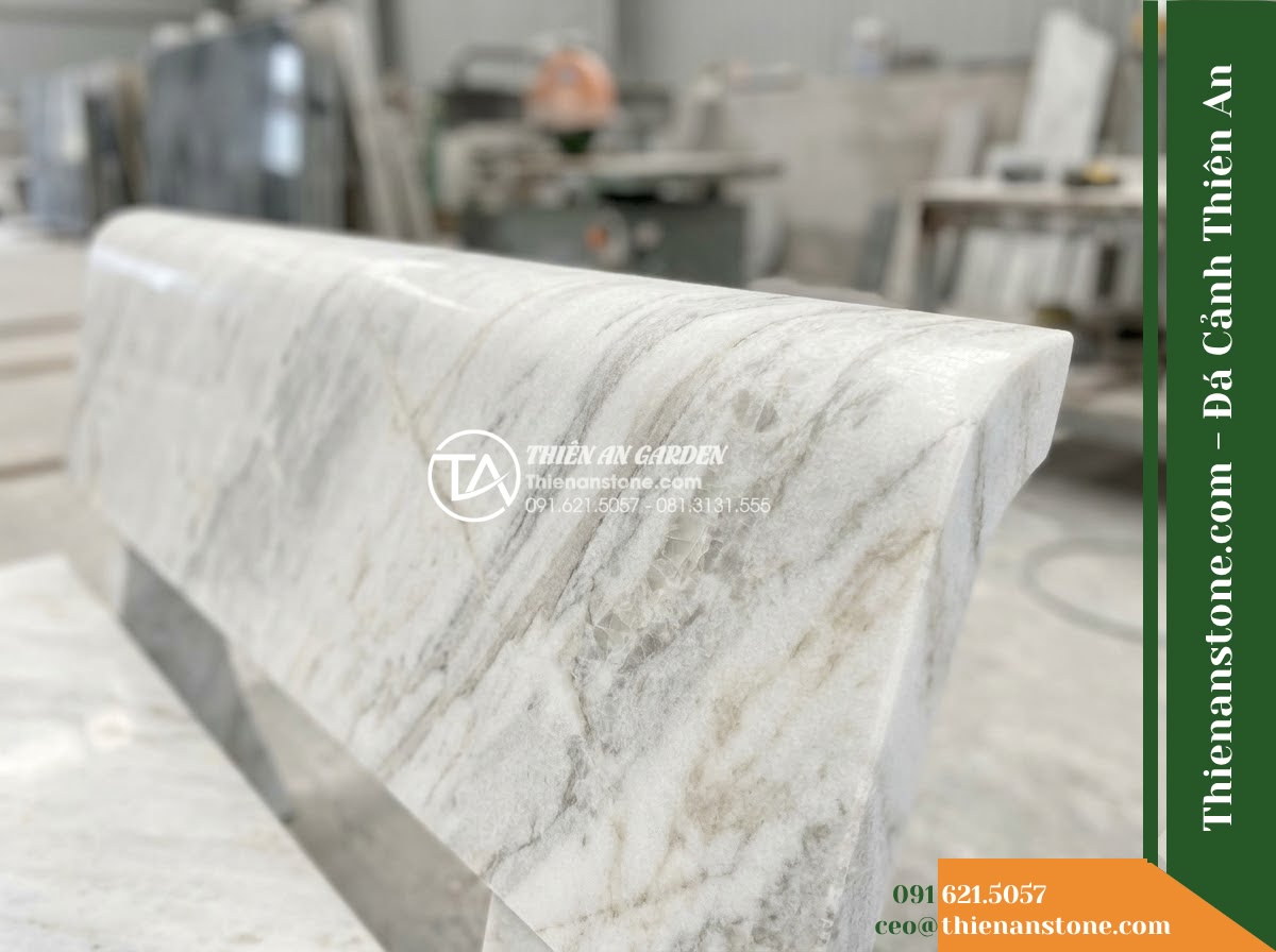 Ghế Đá Sân Trường Tương Lai – Kích thước 160 x 48 x 80 cm – Kiểu dáng tựa vòm thấp, chân cong cân đối. Chất liệu đá Xanh rêu - Hình 3 Ghế Đá Sân Trường Tương Lai – Kích thước 160 x 48 x 80 cm – Kiểu dáng tựa vòm thấp, chân cong cân đối. Chất liệu đá Xanh rêu - Stone bench of green moss stone beside a cascading water feature at night, illum