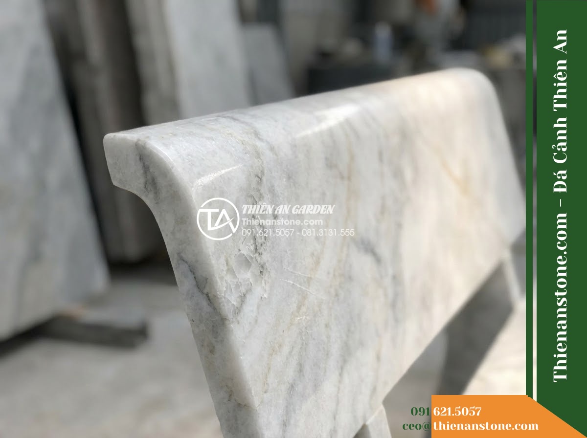 Ghế Đá Sân Trường Vững Bước – Kích thước 175 x 48 x 80 cm – Kiểu dáng tựa cong thấp, hai đầu vuông. Chất liệu đá vân mây - Hình 2 Ghế Đá Sân Trường Vững Bước – Kích thước 175 x 48 x 80 cm – Kiểu dáng tựa cong thấp, hai đầu vuông. Chất liệu đá vân mây - A cloud marble stone bench placed in a lush Vietnamese garden, wide angle shot s