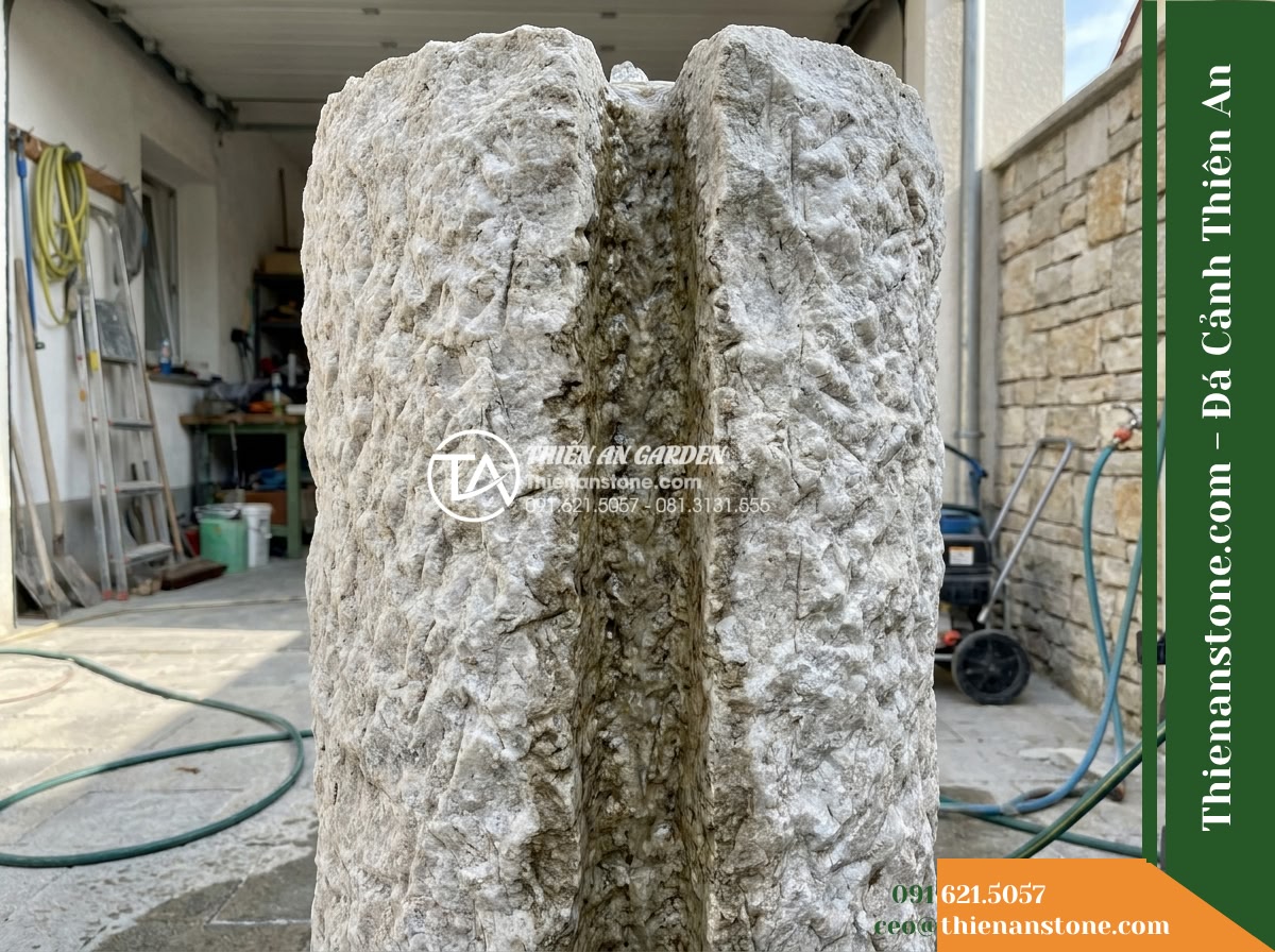 Trụ Phun Khối Thô Bổ Đôi Rãnh Nước, D45cm Cao 1m - Hình 16 Trụ Phun Khối Thô Bổ Đôi Rãnh Nước, D45cm Cao 1m - A rear maintenance perspective shot of the stone water column installation showi
