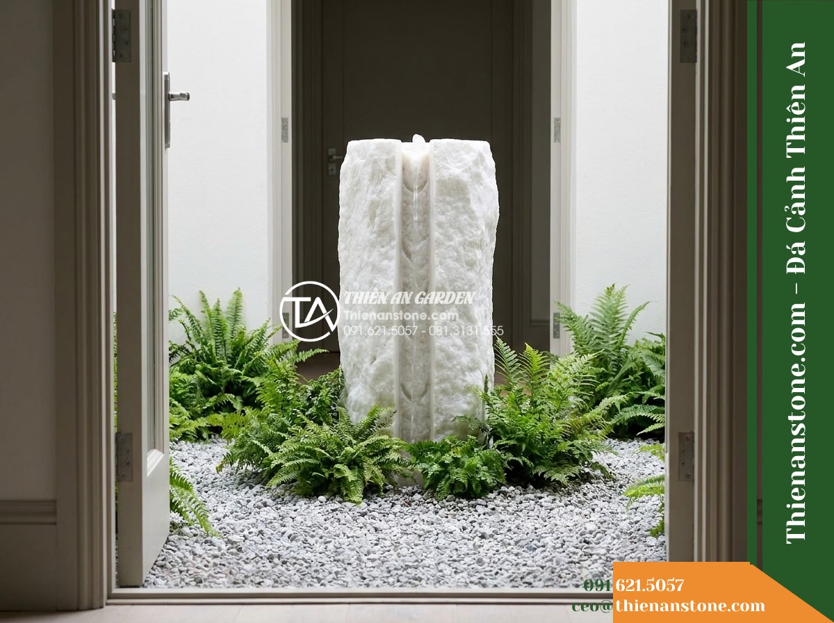 Trụ Phun Khối Thô Bổ Đôi Rãnh Nước, D45cm Cao 1m - Hình 9 Trụ Phun Khối Thô Bổ Đôi Rãnh Nước, D45cm Cao 1m - A realistic daytime architectural perspective shot taken from an open doorway lo