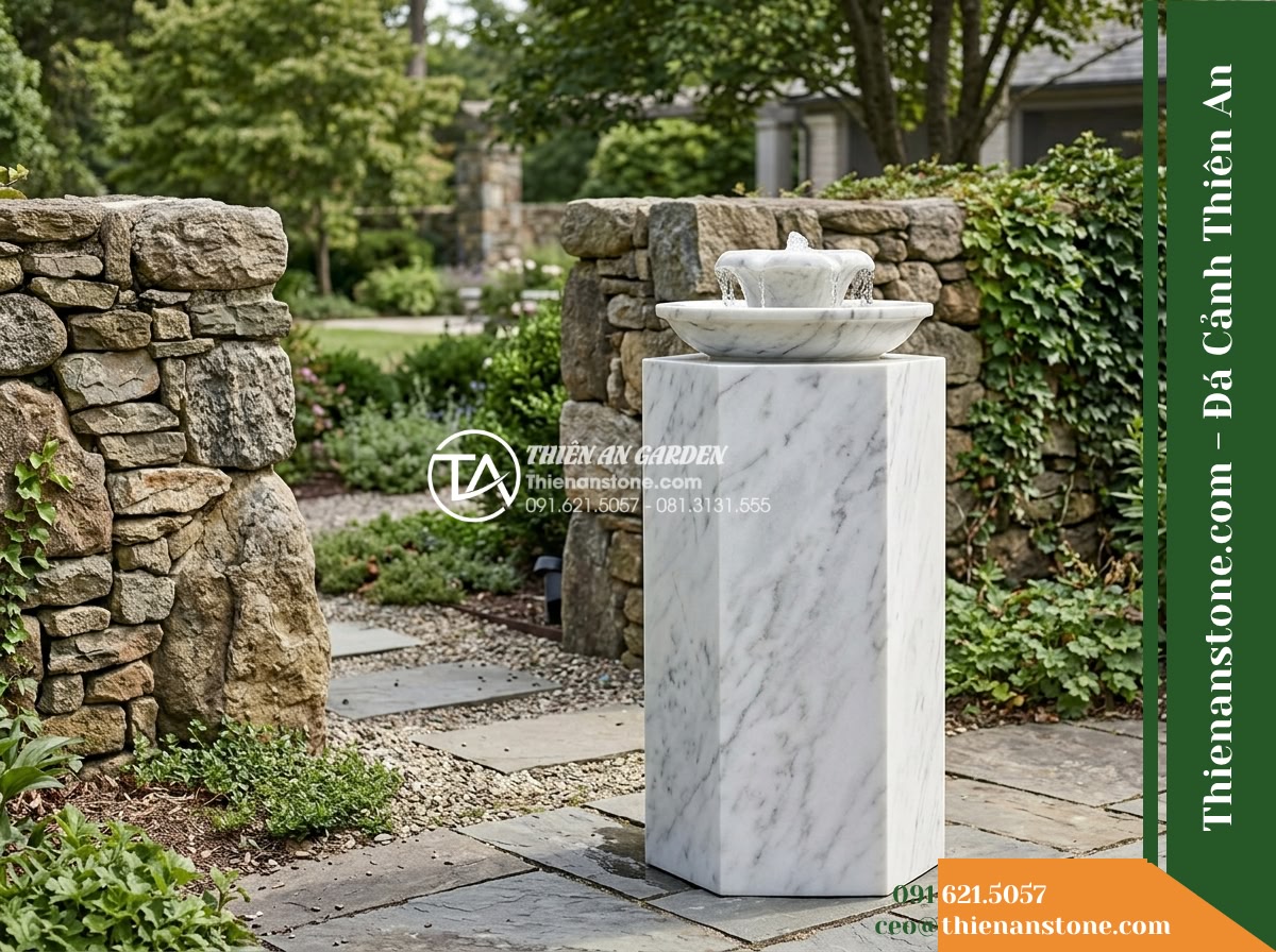 Trụ Phun Lục Giác Đỉnh Bát Phun, D40cm Cao 1m - Hình 16 Trụ Phun Lục Giác Đỉnh Bát Phun, D40cm Cao 1m - Rear perspective of the outdoor stone fountain setup illustrating generous maint