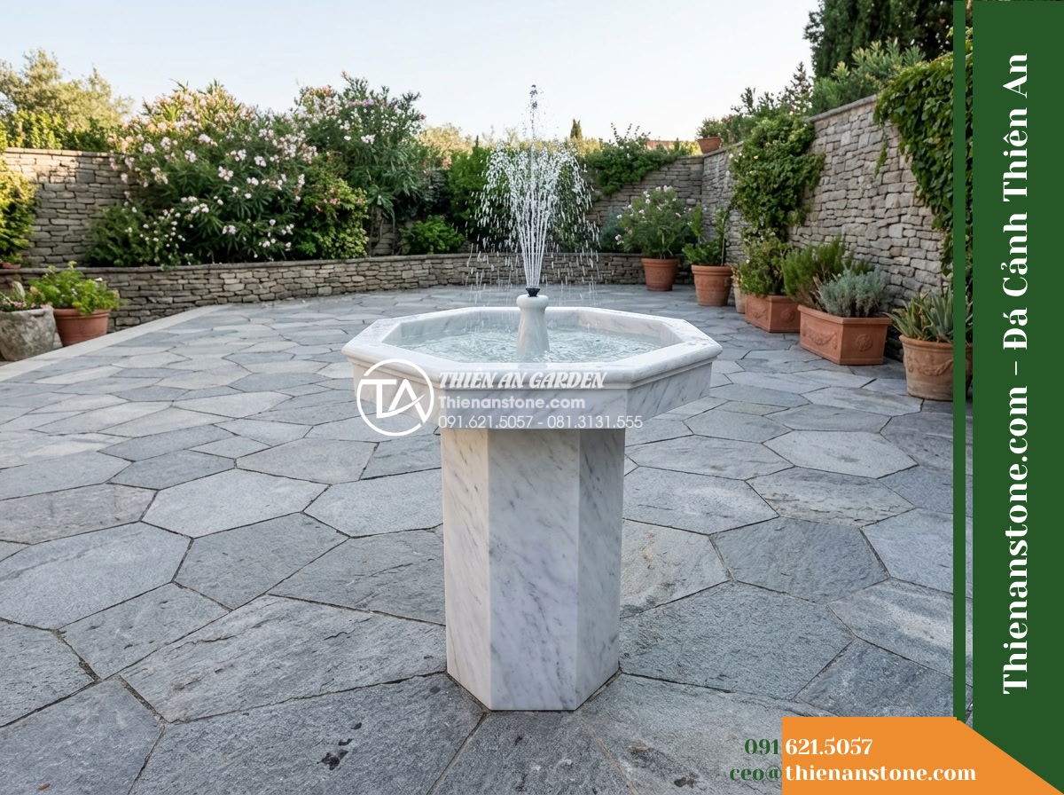 Trụ Phun Lục Giác Đỉnh Bát Phun, D40cm Cao 1m - Hình 5 Trụ Phun Lục Giác Đỉnh Bát Phun, D40cm Cao 1m - Wide ground-level shot displaying a one-meter-tall hexagonal stone fountain on a