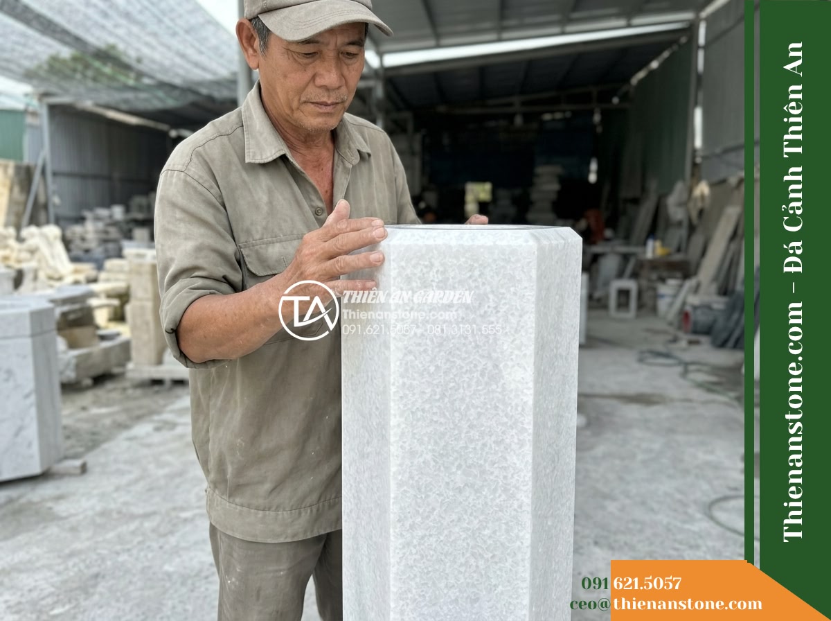 Trụ Phun Lục Giác Mài Bóng Nhẹ, D35cm Cao 80cm - Hình 19 Trụ Phun Lục Giác Mài Bóng Nhẹ, D35cm Cao 80cm - Master stone artisan meticulously inspecting the bevel edge and honed finish of
