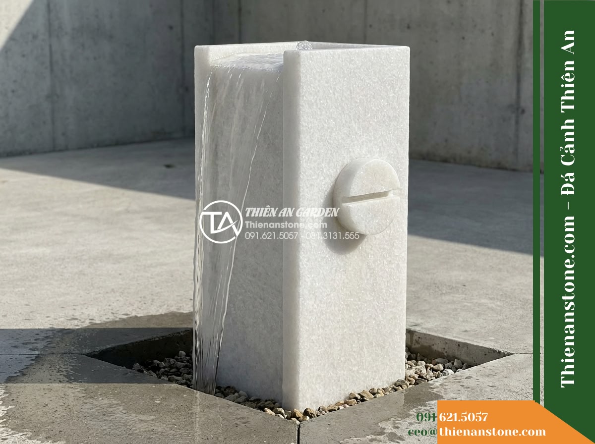 Trụ Phun Vuông Giữ Vết Cắt Đĩa, 30x30cm Cao 90cm - Hình 8 Trụ Phun Vuông Giữ Vết Cắt Đĩa, 30x30cm Cao 90cm - A side profile view capturing the square stone fountain in operation. Water flow
